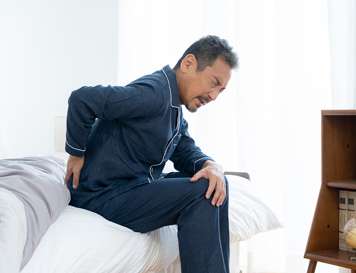 合わないマットレスで腰痛になる男性”