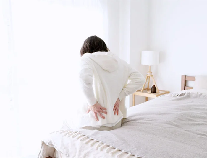 起床時に腰に痛みを覚える女性